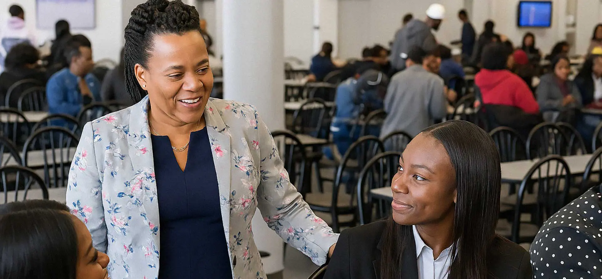 Manager talking to students in dining hall