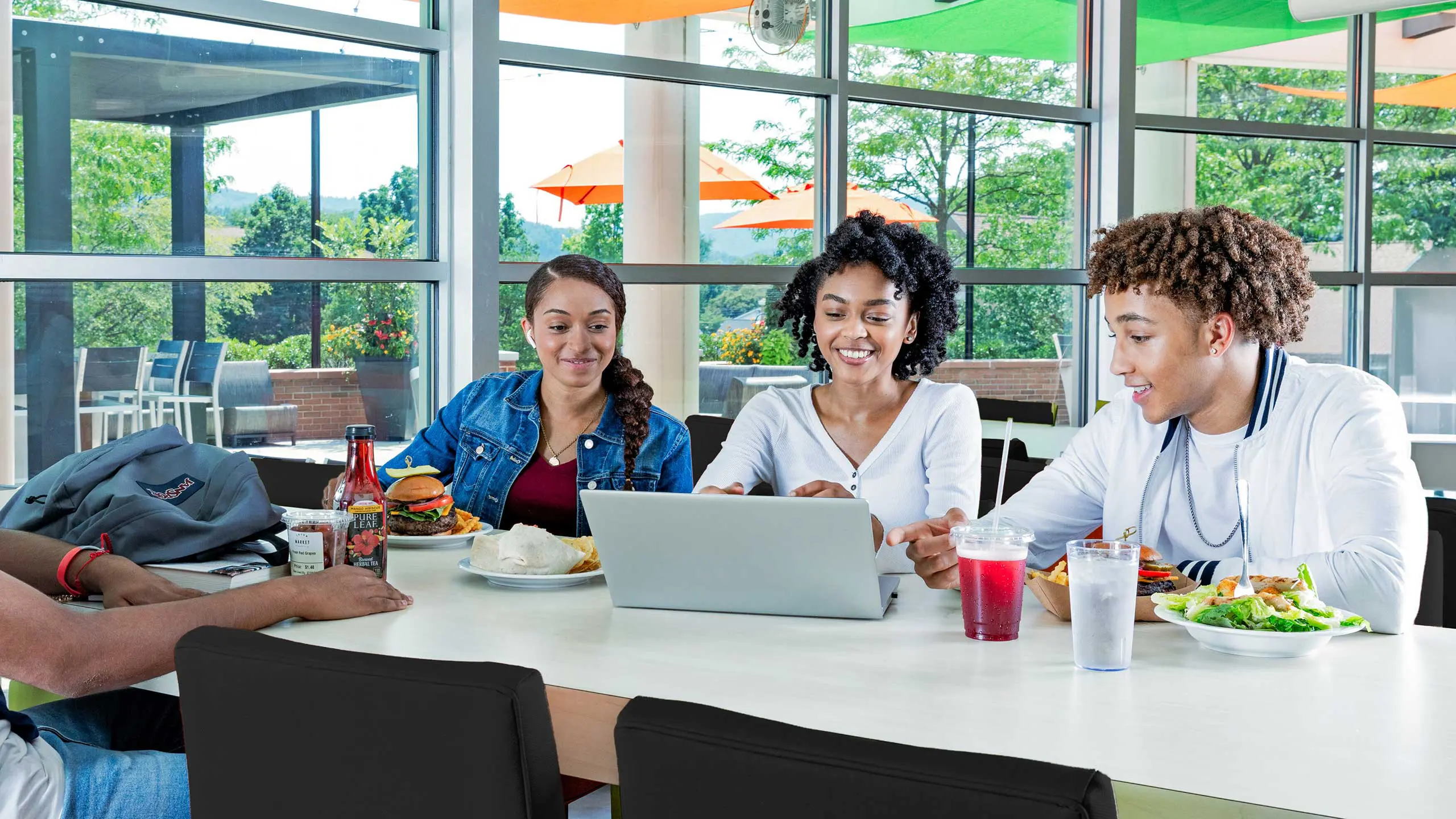Three students sitting in dining hall