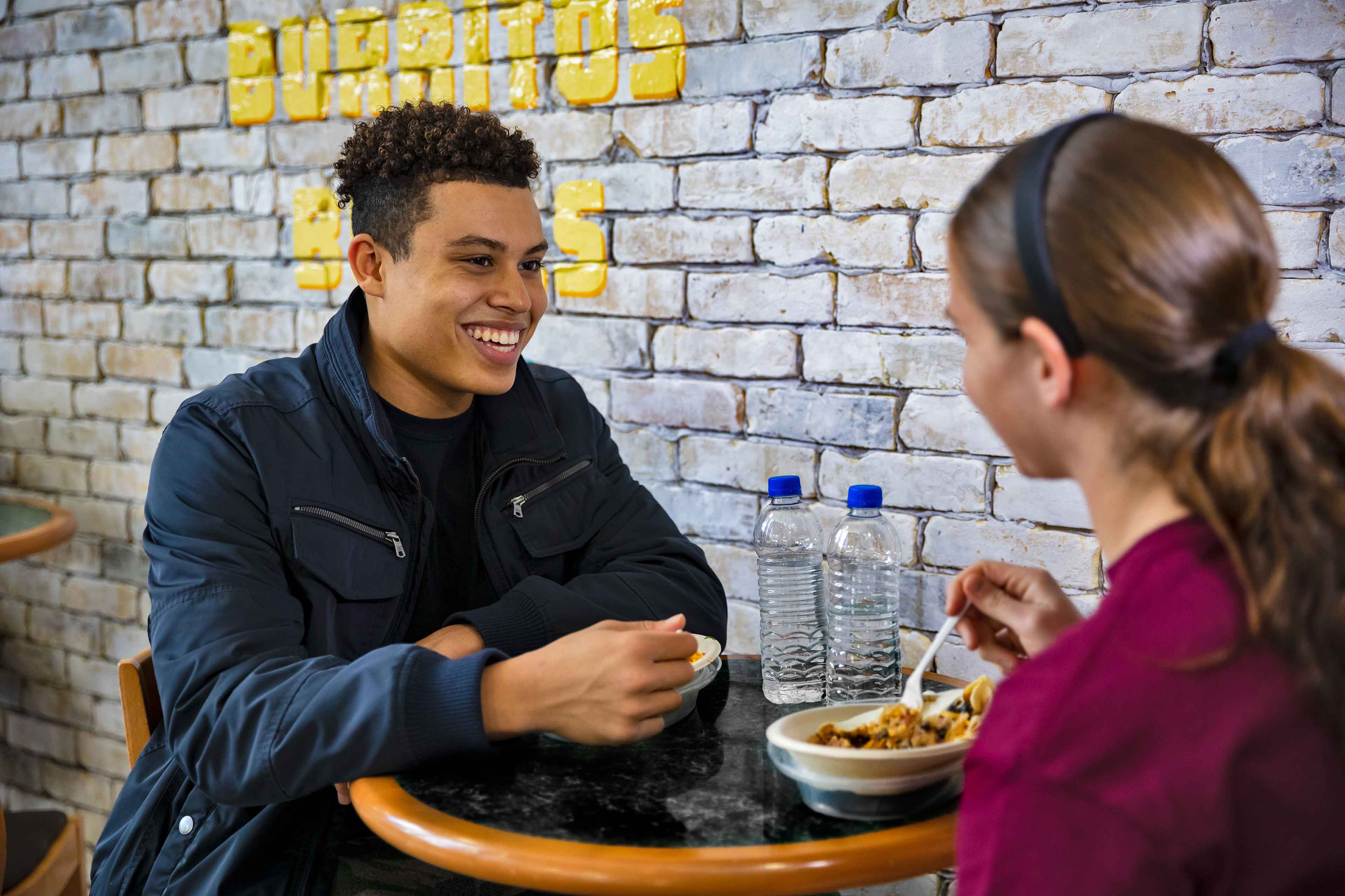 Two students sitting at a table enjoying a meal